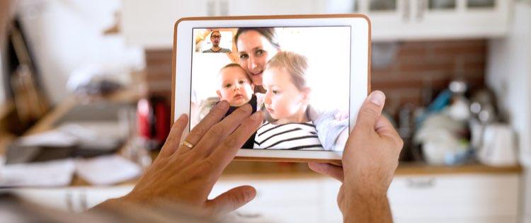Person video chatting with woman and two children on a tablet device