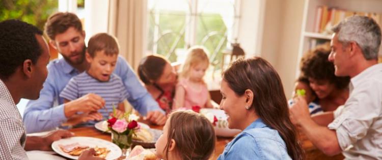 Photo of neighborhood families, three couples and four kids, sitting together eating brunch.