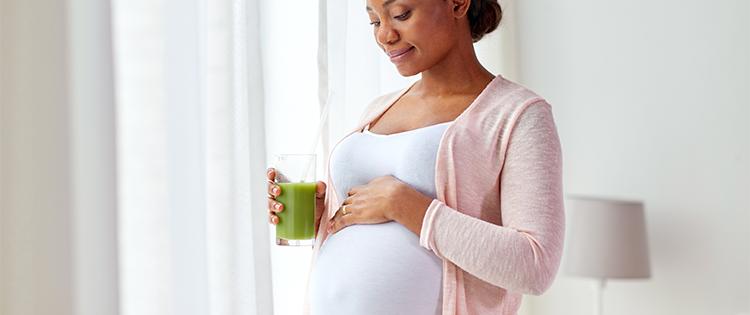 A pregnant woman holding a smoothie