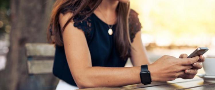 Woman sitting at table texting 