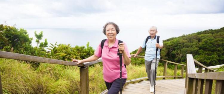 Photo of a senior couple walking up a gently sloped path.