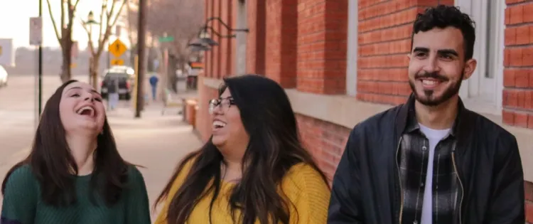 Two women and a man walking down the street.