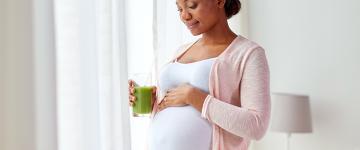 A pregnant woman holding a smoothie