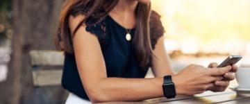 Woman sitting at table texting 