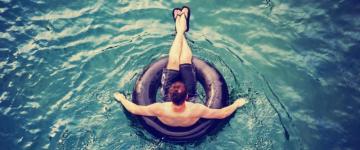 Photo of a man floating on an inner tube.