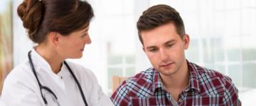 Photo of a man listening to his doctor as she describes medication options